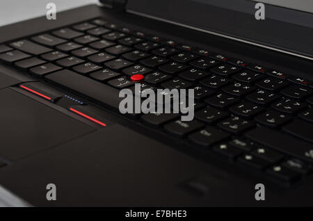 Black laptop keyboard with red track ball Stock Photo