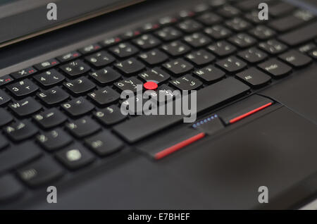 Black laptop keyboard with red track ball Stock Photo