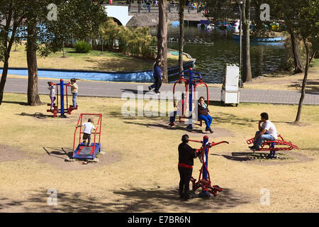 Unidentified people using public fitness equipment in Alameda Park on August 8, 2014 in Quito, Ecuador Stock Photo