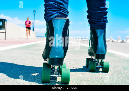 closeup of a young man roller skating on a no traffic road Stock Photo