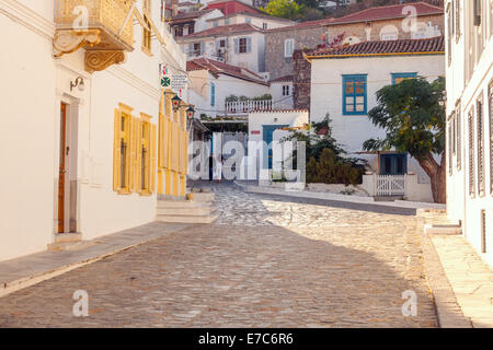 A couple pass along a cobbled street in the historic and traffic free Greek island of Hydra, where donkeys are still used to mov Stock Photo