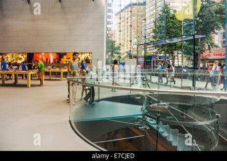 view across Apple store interior to Broadway entrance with customers browsing tables displaying accessible product Manhattan Stock Photo
