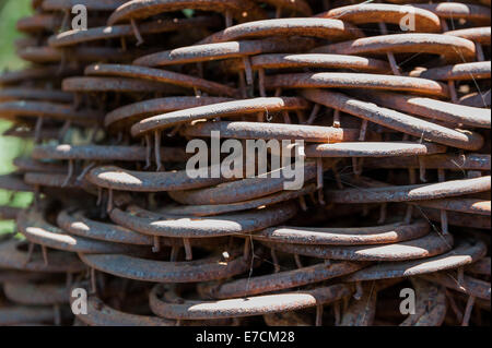 Old & used horse shoes piled up as a modern statue in an artisan shop in Los Alamos, California Stock Photo