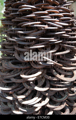 Old & used horse shoes piled up as a modern statue in an artisan shop in Los Alamos, California Stock Photo