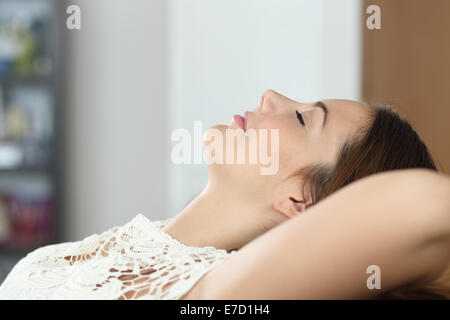Side view of a woman relaxing and sleeping on the couch at home Stock Photo
