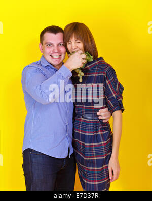 Young couple eating grapes, photographed in the studio Stock Photo