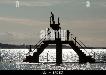 Youths diving and jumping from a sea bathing area diving platform, St Malo, Britanny, France Stock Photo