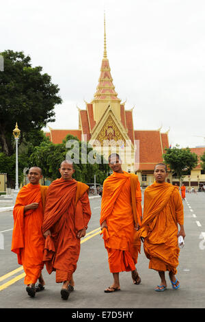 Monks in orange robes walking on the street outside of the Royal Palace in Phnom Penh, Cambodia. A Stock Photo