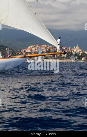 Imperia, Italy. 14th September 2014. A crew member on the bowsprit in front of Imperia. Vele d'Epoca is a vintage yacht competition held every two years in Imperia. Stock Photo