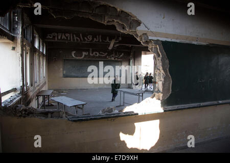 Gaza. 14th Sep, 2014. Palestinian students are seen inside their damaged classroom on the first day of the school year in al-Sheiaeiya neighborhood in the east of Gaza City, on Sept 14, 2014. School year started in the Gaza Strip on Sunday after a three-week delay due to severe destruction of schools caused by an Israeli large-scale offensive waged on the enclave that ended on Aug. 26. © Wissam Nassar/Xinhua/Alamy Live News Stock Photo