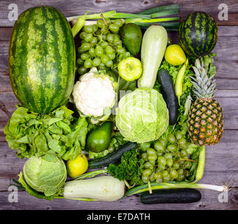Huge group of fresh green fruit and vegetables on wood background - Concept of healthy green food Stock Photo