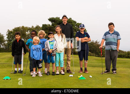 Young junior golfers are having a putting lesson on the practice putting green at Teignmouth Golf Club. Stock Photo