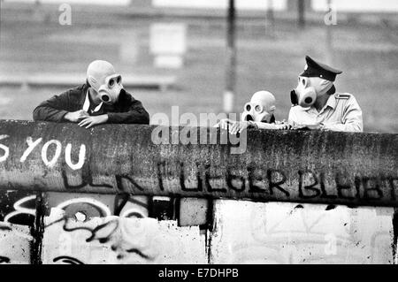 East German border guards wearing gas mask look over the wall onto Potsdamer Platz in Berlin, Germany, 21 June 1988. After stones were thrown at the police by West Berlin occupiers of the Lenne Triangle, tear gas was used. The enclave belonged to East Berlin, but was part of the territory exchange on 01 July 1988, becoming part of the West Berlin district of Tiergarten. Photo: Agentur Voller Ernst - NO WIRE SERVICE Stock Photo