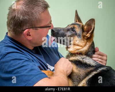 Young man playing with his german shepherd puppy Stock Photo