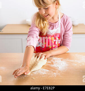 Girl 6-7 years preparing to make a pizza, stretching the dough Stock Photo