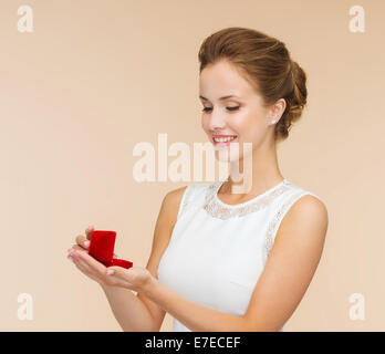 smiling woman holding red gift box with ring Stock Photo