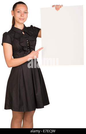 Beautiful girl holding blank white placard and pointing at it Stock Photo