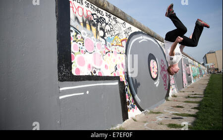 Berlin, Germany. 15th Sep, 2014. Artistically, Steven jumps from the wall at the 'East Side Gallery' in Berlin, Germany, 15 September 2014. Weather-wise, September shows its best side in Berlin. The 'East Side Gallery' is a part of the former Berlin Wall. PHOTO: Joerg Carstensen/dpa/Alamy Live News