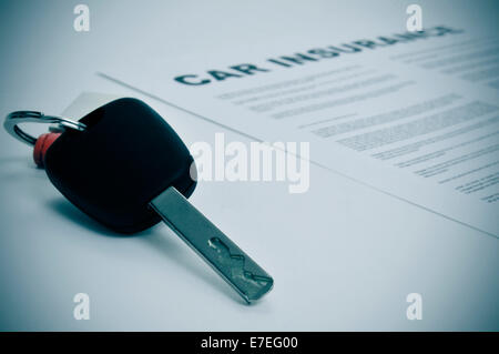 closeup of a car key and a car insurance policy Stock Photo