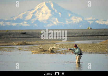 Woman fly fishing river in waders and fishing vest USA Stock Photo