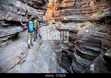 Hikers walk along Deer Creek Narrows in the Grand Canyon outside of Fredonia, Arizona November 2011.  The 21.4-mile loop starts at the Bill Hall trailhead on the North Rim and descends 2000-feet in 2.5-miles through Coconino Sandstone to the level Esplana Stock Photo