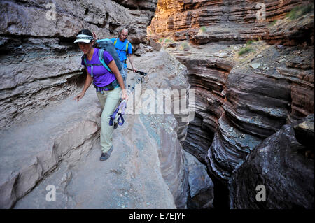 Hikers walk along Deer Creek Narrows in the Grand Canyon outside of Fredonia, Arizona November 2011.  The 21.4-mile loop starts at the Bill Hall trailhead on the North Rim and descends 2000-feet in 2.5-miles through Coconino Sandstone to the level Esplana Stock Photo