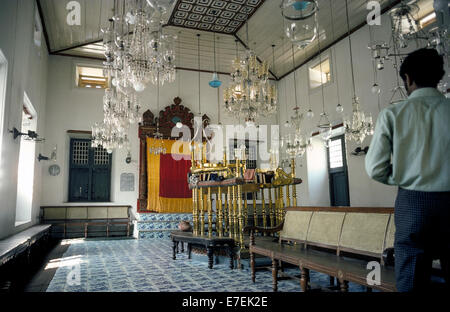 The Paradesi Synagogue that was originally built in 1568 for the Jewish community in Kochi (Cochin) in Kerala state, India, is one of the oldest functioning synagogues in the world. Visitors are welcome to view its historical treasures that include a teak ark (behind the gold and red curtain] with scrolls of the Torah and gold and silver crowns.  In open view are the brass-railed pulpit, 18th-Century blue floor tiles from China, and glass chandeliers and lamps imported in the 1800s from Europe. Photographed in 1974. Stock Photo