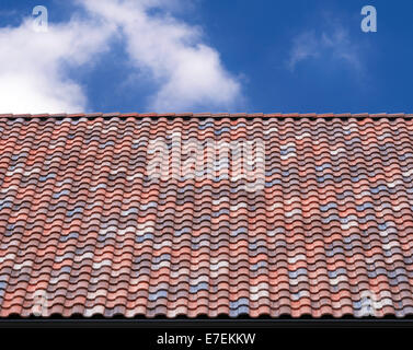 Multicolored roof tile against blue sky and white clouds Stock Photo