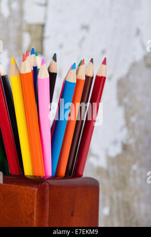 Group of colored pencils in pencil holder against gray background Stock Photo