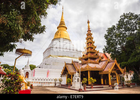 Ancient golden pagoda and myanmar style viharn at buddhist temple in lampang province, thailand Stock Photo