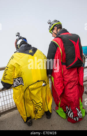 Base jumpers wearing wing suites prepare to jump from the Aiguille Du midi above Chamonix, France. Stock Photo