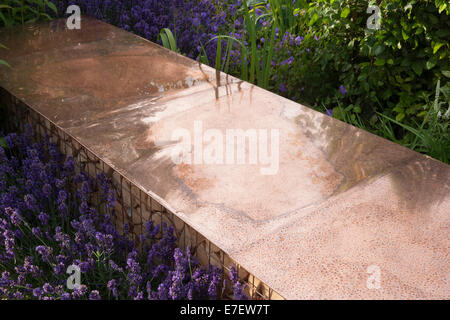 Garden - Vestra Wealth's Vista - view of garden bench made from copper with log pile for wildlife insect habita Stock Photo