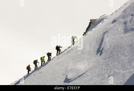 Climbers on the arete leading up from the Vallee Blanche to the Aiguille Du Midi above Chamonix, France. Stock Photo