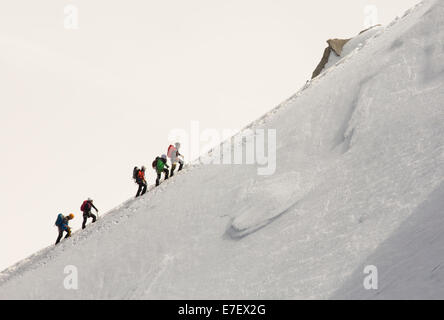 Climbers on the arete leading up from the Vallee Blanche to the Aiguille Du Midi above Chamonix, France. Stock Photo