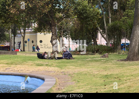 Unidentified men lying on the lawn in the Alameda Park on August 8, 2014 in Quito, Ecuador Stock Photo