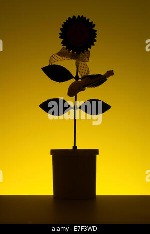 Dancing flower as a silhouette on a yellow background. Stock Photo