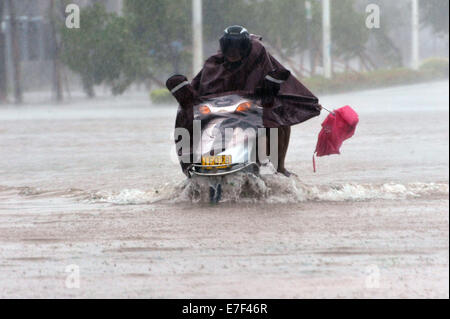 Qionghai, China's Hainan Province. 16th Sep, 2014. People ride on flooded road in typhoon-hit Qionghai City, south China's Hainan Province, Sept. 16, 2014. Typhoon Kalmaegi landed in the island province on Tuesday morning. Credit:  Meng Zhongde/Xinhua/Alamy Live News Stock Photo