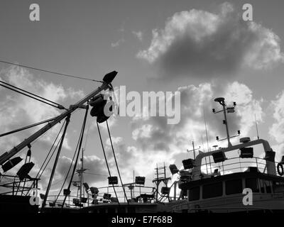 Night-fishing ships with visible fishing-lamps installed on-board during sunset Stock Photo