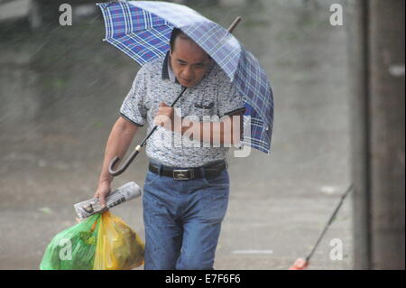 Qionghai, China's Hainan Province. 16th Sep, 2014. A man walks in rain in typhoon-hit Qionghai City, south China's Hainan Province, Sept. 16, 2014. Typhoon Kalmaegi landed in the island province on Tuesday morning. Credit:  Meng Zhongde/Xinhua/Alamy Live News Stock Photo