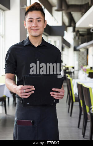 Asian waiter standing in restaurant Stock Photo