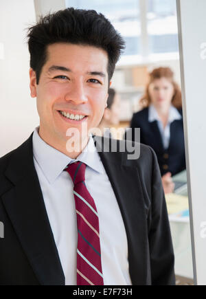 Mixed race businessman smiling in office Stock Photo