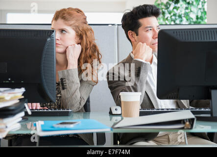 Business people bored at desks Stock Photo