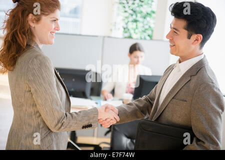 Business people shaking hands in office Stock Photo