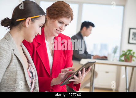 Businesswomen using digital tablet in office Stock Photo