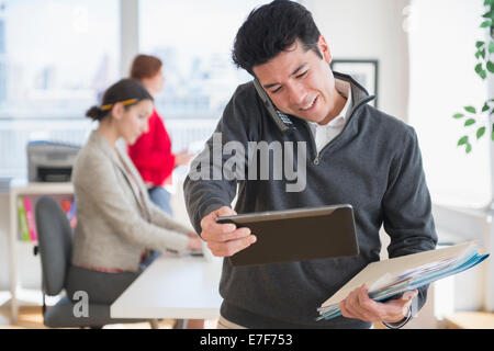 Businessman talking on cell phone in office Stock Photo