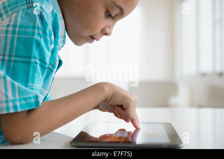 Mixed race boy using tablet computer
