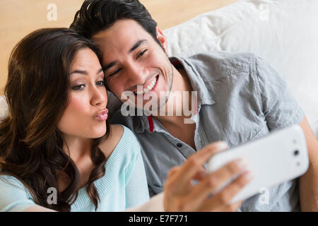 Couple taking pictures together on sofa Stock Photo
