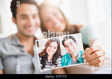 Couple holding photograph of themselves Stock Photo