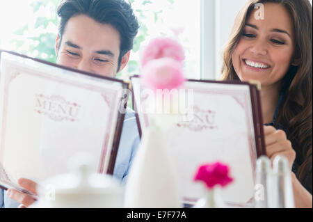 Couple reading menus in restaurant