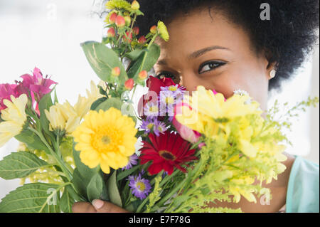 African American woman holding bouquet of flowers Stock Photo